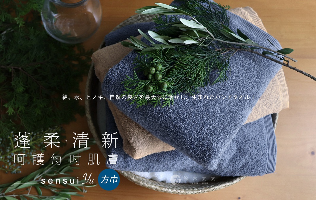 一疊深藍色和淺棕色的精梳棉方巾，上方裝飾著綠葉枝條。