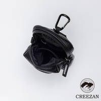 一個黑色的皮革紋理高爾夫球收納腰包，有拉鍊開合，頂部有一個登山扣，側面有一個印有品牌名稱的吊牌。