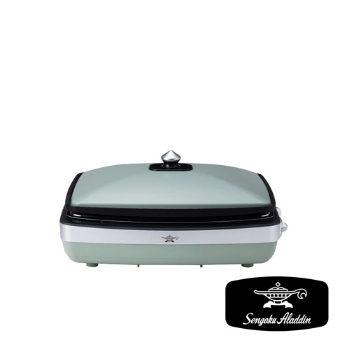 淺綠色烤盤，帶有銀色把手和黑色邊緣，置於白色背景上。烤盤上方有一個銀色圓形旋鈕。底部有產品品牌標誌。