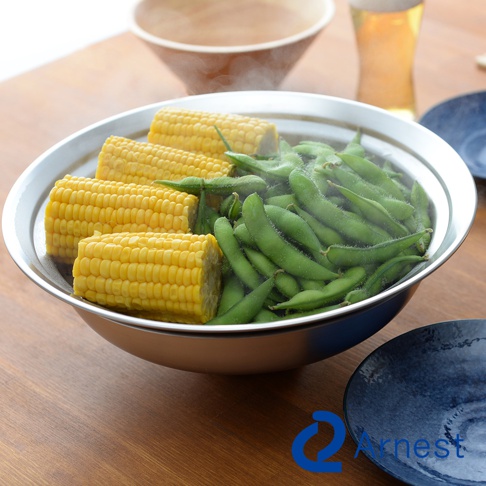 不鏽鋼蒸盤內盛放著切塊的玉米和毛豆，蒸氣繚繞。