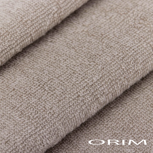 近拍 BISAI 今治耐用夢幻柔彩迷你毛巾，觸感細膩，材質為柔軟的棉質，呈現淺棕色的細緻織紋，毛巾疊放，部分區域有光澤。