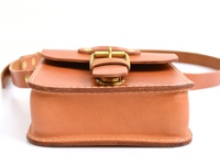 經典款棕色皮革單肩包，採用皮扣開合設計，配有可調節的皮革肩帶。包身線條簡潔，縫線精緻，展現職人手作質感。