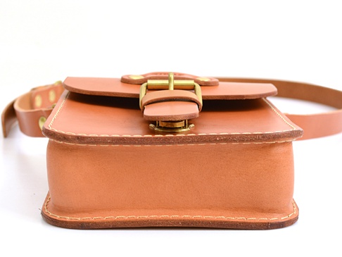 經典款棕色皮革單肩包，採用皮扣開合設計，配有可調節的皮革肩帶。包身線條簡潔，縫線精緻，展現職人手作質感。