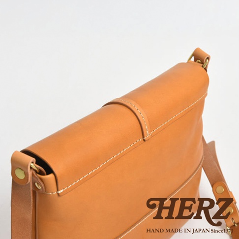 HERZ 品牌標誌，日本手工製作皮革馬鞍包，特寫視角。