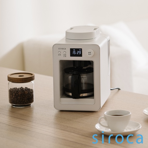 白色 SC-A3520 自動研磨咖啡機，搭配玻璃咖啡豆罐和白色咖啡杯，置於木質桌面。咖啡機正面有黑色操作面板、數位顯示螢幕及玻璃咖啡壺。