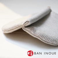 兩件 Tricot 棉麻防燙鍋套，一淺一深，以細膩的織紋和自然的亞麻色調呈現。