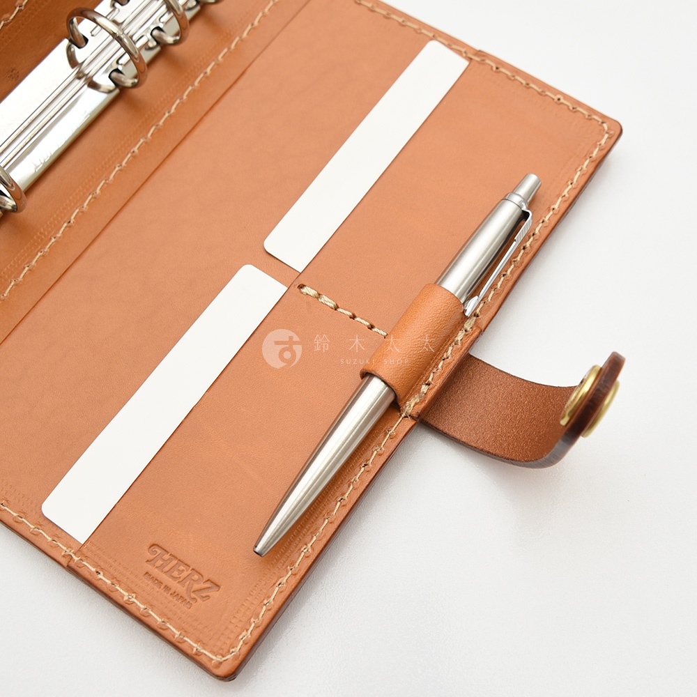 職人手作皮革手帳，棕色皮革內頁，附有銀色金屬筆，筆套為同色皮革，內有文件夾層與六孔活頁夾。