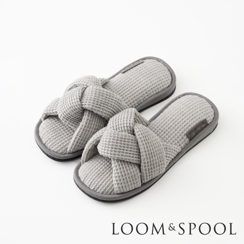 一雙灰色交叉編織鬆餅紋室內拖鞋，左腳拖鞋在右腳拖鞋前方，兩雙拖鞋皆有灰色鬆餅紋鞋面與灰色鞋底。
