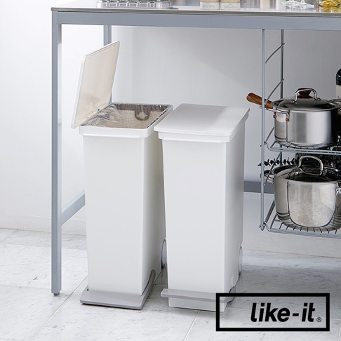 兩個白色直立型塑膠腳踏式分類垃圾桶，其中一個垃圾桶蓋子打開，內有垃圾袋。垃圾桶底部有灰色腳踏板和輪子。