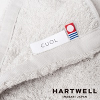 淺灰色 CUOL 今治毛巾，織有品牌標籤，毛圈蓬鬆柔軟，邊緣有流蘇細節。