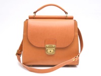 職人手作屋瓦風兩用單肩包，以淺棕色皮革製成，包款設計簡約，配有金色鎖扣及提把，可手提或斜肩背。