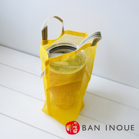 黃色網狀提把收納袋，內部裝有透明罐子，袋子材質輕薄透氣，有兩個條紋提把。