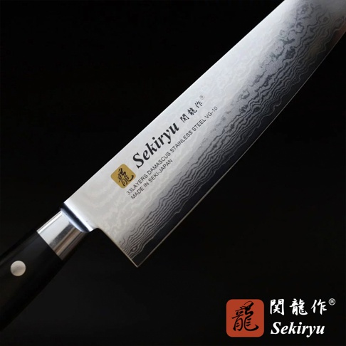 VG10不鏽鋼33層大馬士革紋路牛刀，刀刃銀白色，帶有明顯的波浪紋理，刀柄為黑色。