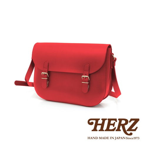 紅色皮革經典馬鞍包，配有兩個金色針扣皮帶和可調式肩帶。