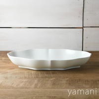 Tsudoi 淡青白釉美濃燒輪花長盤，一個白色、輪花造型的長方形陶瓷盤，置於木質桌面，背景為白色木板牆。