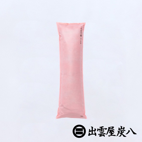 這是一包粉紅色長條形的出雲屋炭八櫥櫃專用調濕木炭，採用雙層不織布材質包裝，產品邊緣印有品牌名稱與標誌，整體設計簡約適合放置於狹窄空間進行除臭與調節濕度。
