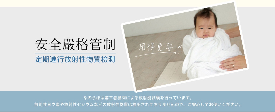 UB珪藻土瞬間吸水置物墊（圓形款）的圖片，顯示一位嬰兒被白色毛巾包裹，躺在淺色地板上。