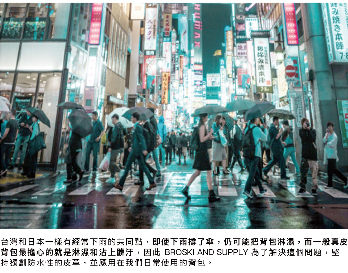 一群人在雨中撐傘走在有霓虹燈招牌的城市街道上，地面濕滑反光。