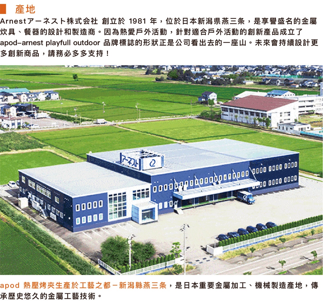 藍色與白色相間的建築物，設有大片落地窗和金屬外牆，建築前方有停車場及多輛汽車，周圍環繞著綠色田野和幾棟小型房屋。