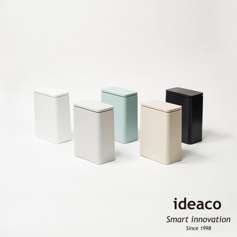 五個不同顏色的防臭按壓式垃圾桶，包括白色、淺灰色、淺藍色、米色和黑色，皆為方形設計，帶有簡潔的蓋子，放置於白色背景上。