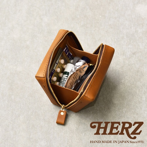 一個打開的棕色皮革收納包，裡面裝有藥丸、藥膏和筆。