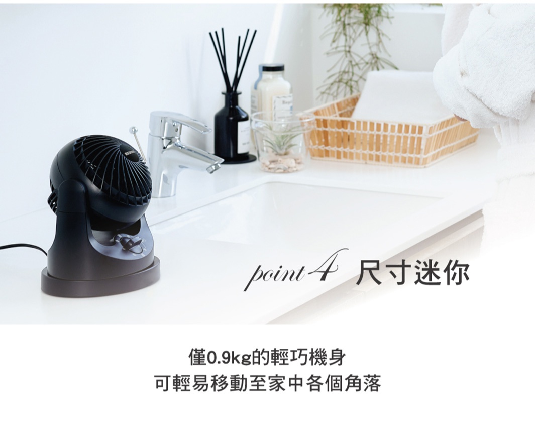 極靜音迷你型空氣循環扇 TAF-MKM10，黑色，具有圓形網罩和可調節傾斜角度的底座，放置在白色檯面上，背景有水龍頭、擴香瓶、玻璃杯及草本植物，以及一個藤編籃子。