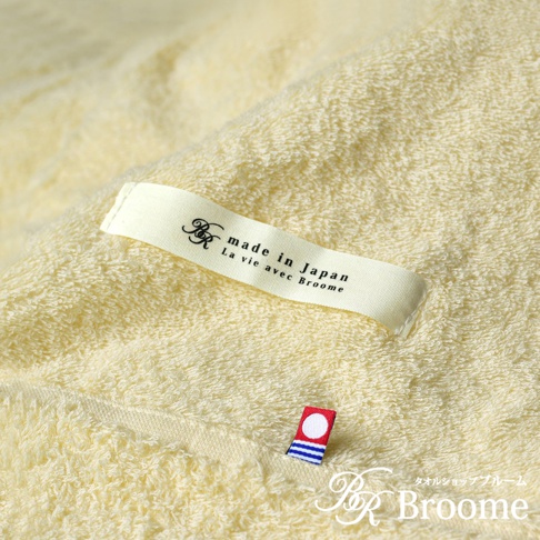 淺黃色今治毛巾被，觸感柔軟，帶有「made in Japan」標籤及小巧的日本國旗裝飾。
