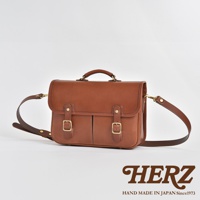 一款棕色皮革製成的雙肩帶公事包，配有頂部提把、兩條前袋和金屬扣環。