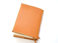 職人手作皮革附繩書套，天然皮革原色，以手工縫線裝訂，書套側邊有綁繩設計，可容納書籍。