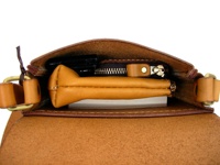 職人手作皮革翻蓋直式單肩包，淺棕色，皮革材質，包內有手機、拉鍊零錢袋及其他物品，搭配黃銅色五金配件。