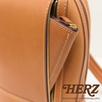 棕褐色皮革立體商務後背包，特寫拉鍊細節，搭配金色拉鍊和縫線，展現職人手作質感。