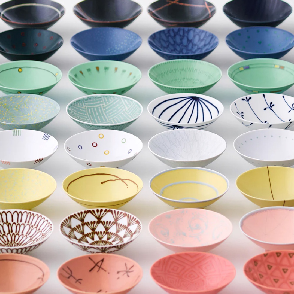 各式平茶碗，包含黑色、藍色、綠色、黃色、粉紅色等顏色，部分碗內有圖案裝飾，材質為陶瓷。