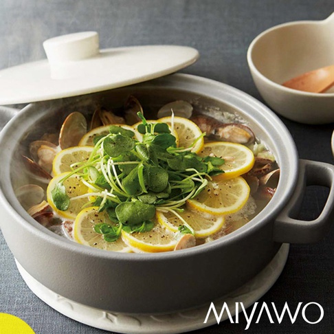 灰白色 IH 系列陶土湯鍋，鍋內裝有蛤蜊、檸檬切片及綠葉蔬菜，湯鍋蓋微開，鍋身有兩個提把，鍋底置於白色防燙墊上。