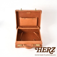 開放式棕褐色皮革手提行李箱，內部有隔層和固定帶，外部有兩個鎖扣和一個提把。