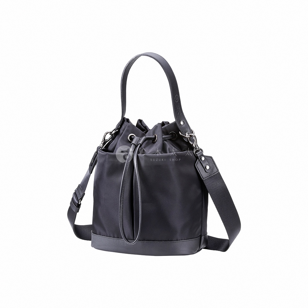 TUTUMU 兩用抽繩水桶包，黑色尼龍材質搭配皮革飾邊，可手提或肩背。