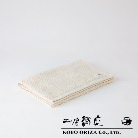 ECOR 天然系人字紋有機棉毛巾，米白色，觸感柔軟，織有明顯的人字紋路，邊緣為白色滾邊。