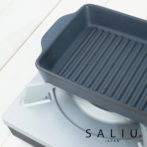 深灰色、帶有烤紋的長方形陶製烤盤，置於銀色爐架上，烤盤邊緣有兩個小提把。