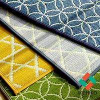 三款榻榻米廚房地墊，分別為藍色、黃色、綠色，皆有白色幾何圖案編織紋路，材質似塑膠或纖維，邊緣有包邊處理。