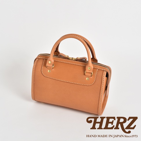 職人手作皮革迷你波士頓包，呈現天然棕色皮革，帶有精緻縫線與金屬拉鍊，造型復古，適合日常攜帶。