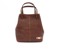 棕色皮革托特包，帶有米白色縫線細節，頂部有兩個手提把，側面有金屬铆釘裝飾，底部有一個品牌金屬銘牌。