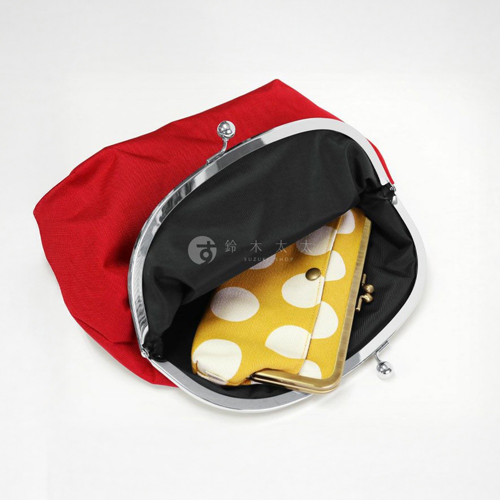 一個紅色的口金包，打開後裡面有一個黃色的波點內袋。