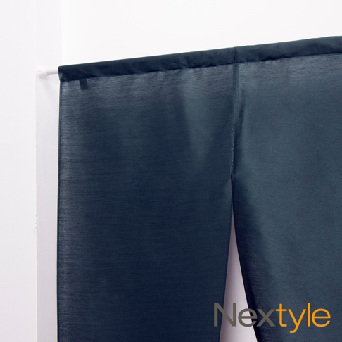 深藍色調的日製防焰門簾，布面帶有細緻的織紋，中間有明顯的開衩，透過白色門框掛起。