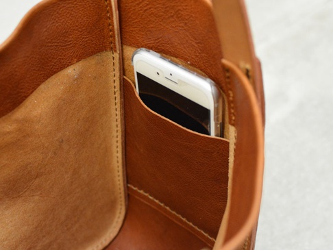 内側には左右にサイドポケットがついています。写真ではスマートフォン(i-phone6s)を入れています。Sサイズだと少し頭が出ます。