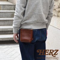 棕色皮革製作的職人手作多用途工作用腰袋，以簡潔的方形設計，固定於牛仔褲腰間。