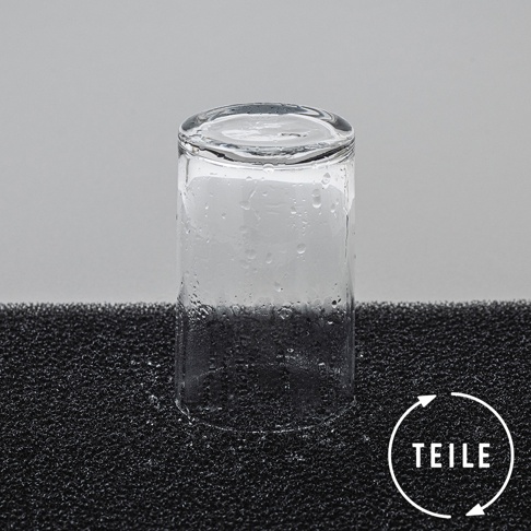 黑色海綿材質瀝水墊上放置一個透明玻璃杯，杯身有水珠，顯示其速乾吸水特性。