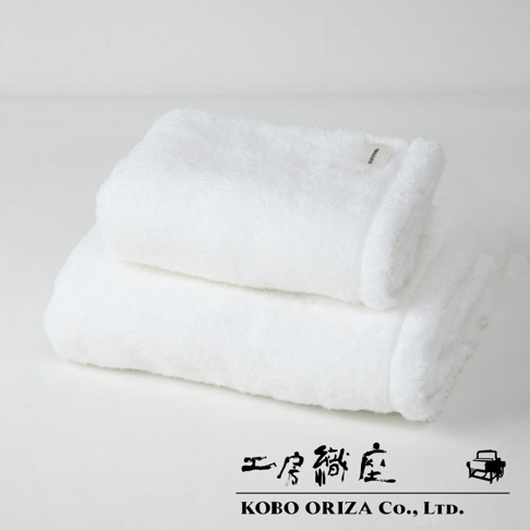 兩條白色今治柔感匹馬棉浴巾堆疊，其中一條浴巾帶有細小的白色品牌標籤。