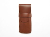 職人手作皮革鋼筆收納筆套，溫暖的棕色皮革，帶有縫線細節，並以皮帶扣固定，設計簡約實用。