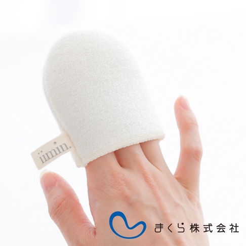 一隻手戴著米白色蠶絲洗臉手套，手套上有「iimin」品牌標籤。