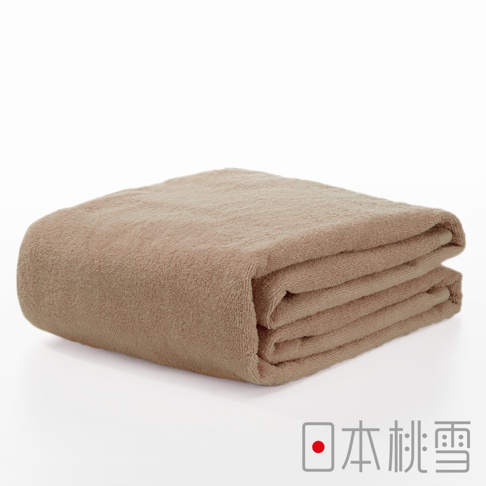 一條深米色超大浴巾，由柔軟的毛圈織物製成，對折後堆疊，呈現蓬鬆的質地。