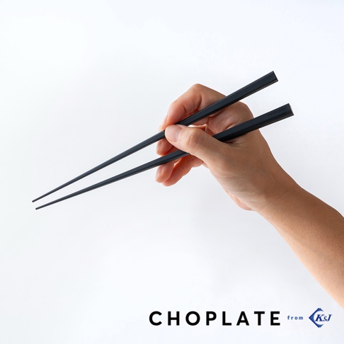 一隻手握著一雙黑色筷子，筷子上印有CHOPLATE字樣，下方有CHOPLATE from KsJ字樣。